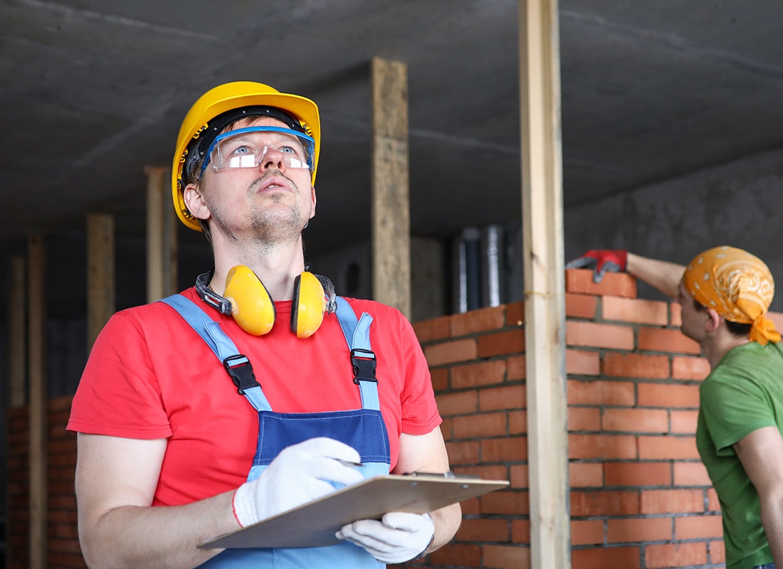 Insurance by Industry - Contractor Wearing Yellow Headphones and Helmet Inspecting a Project Site